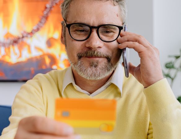 Man holding an orange credit card and a smartphone