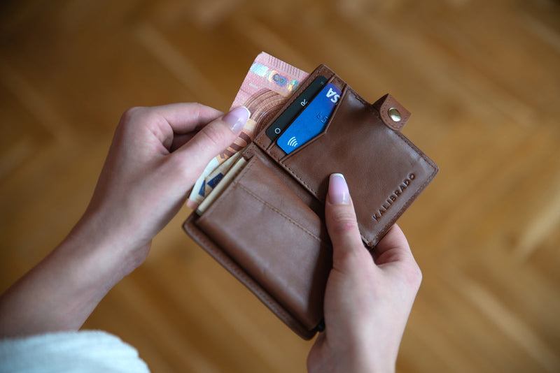 Person holding a leather card wallet