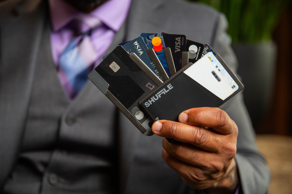 Man in a suit holding four credit cards
