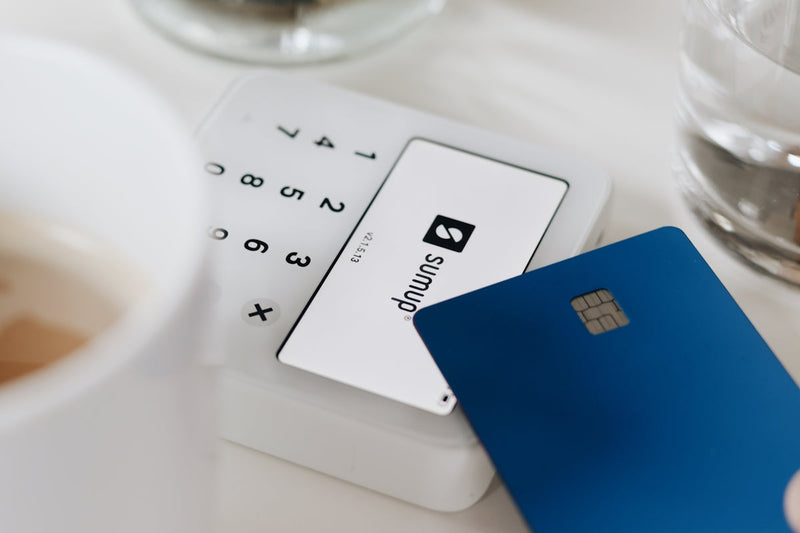 Credit card on a table next to a cup of coffee